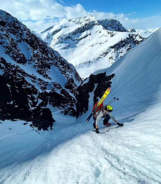 Ski mountaineer climbing a steep snowy slope