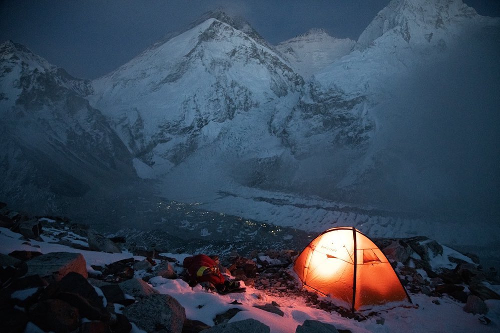 A light tent at night looking toward Everest