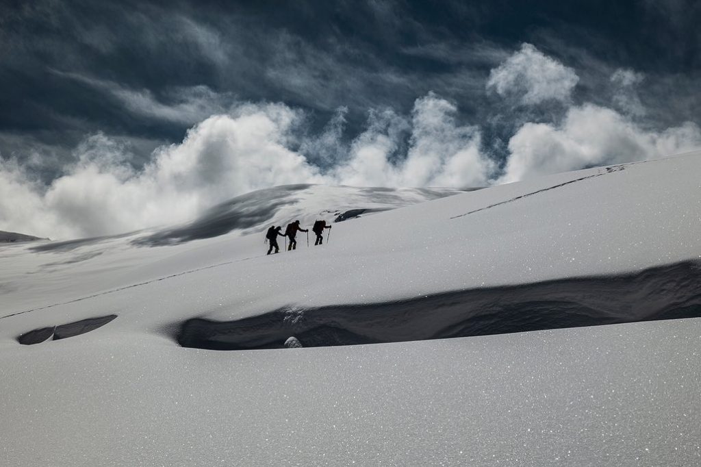 Three climbers moving up a snowy slope on Dhaulagiri