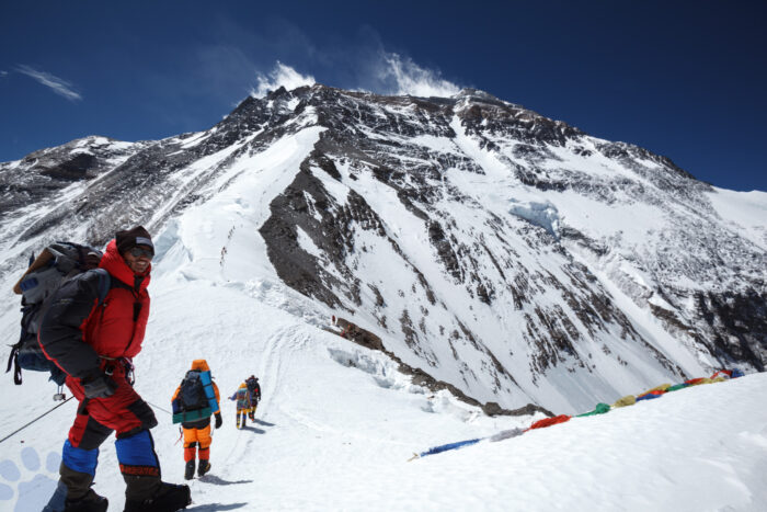 A shera smiles while on the col before a ridge leading to the huge summit area of Everest.