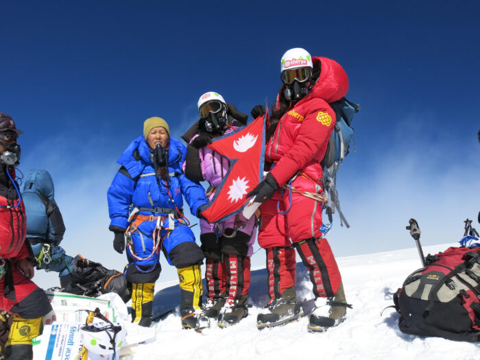 Sherpa climbers on a snowy summit. 