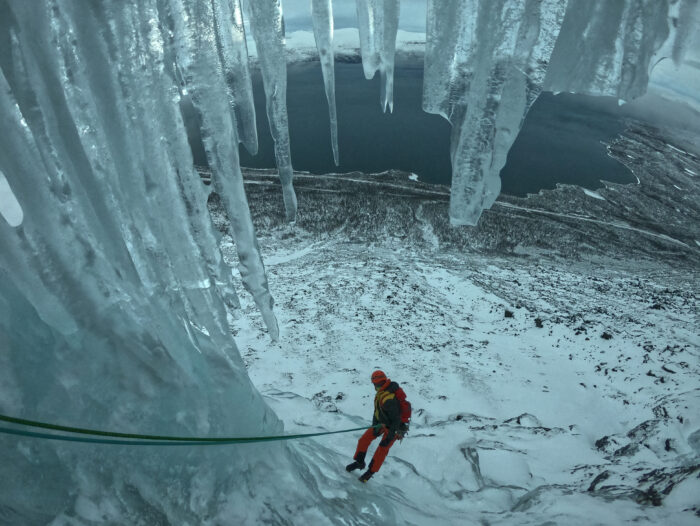 a climber rappels with icicles on top of the route. 
