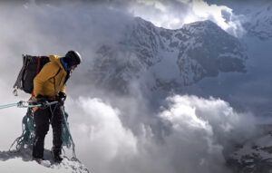 a mountaineer overlooks a cloudy precipice