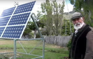 old man standing with solar panels