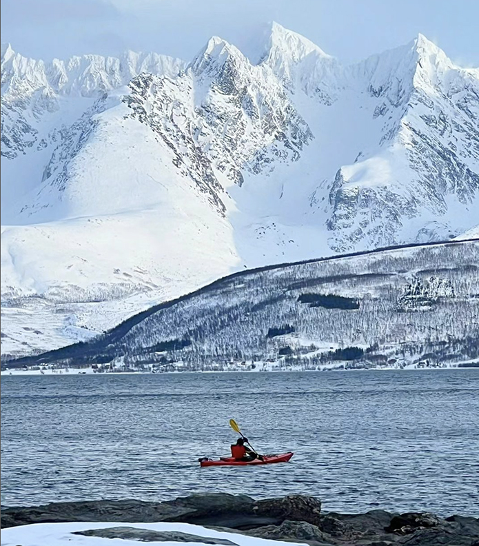 kayaker with backdrop of snowy mountains