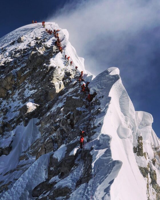 climbers in line along the Hillary Step on a windy day.
