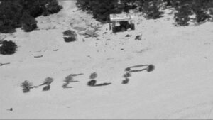 "HELP" spelled out on a beach