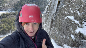 portrait of Robbi Mecus with a climbing helmet, giving a thumb's up