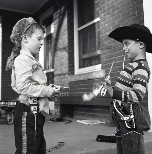 two 1950s boys with toy guns and coonskin/cowboy hats