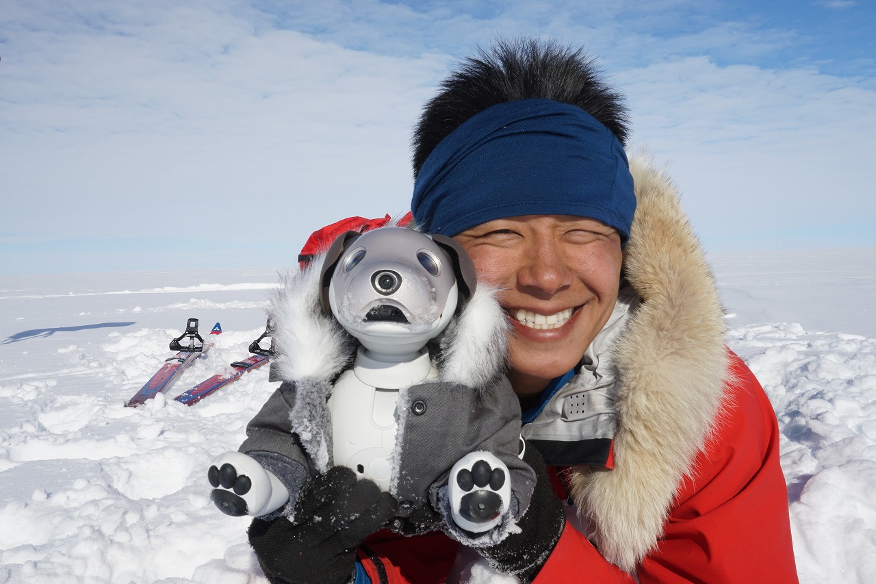 smiling guy in Antarctica with toy robot dog