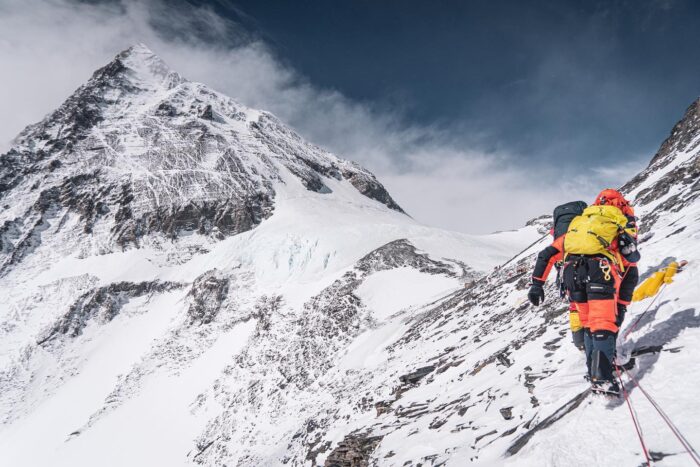 Sherpas traverse from the Lhotse Face towards the South Col of Everest, with the summit in background.