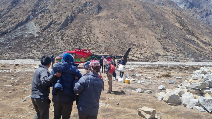 A patient suffering from HACE is helped to a helicopter at the aid post in Pheriche. 