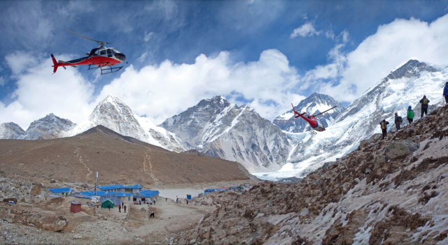 Two helicopters fly toward Everest Base Camp.