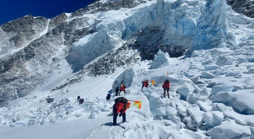 Sherpas on a mace of ice on Everest plant flags to mark the route