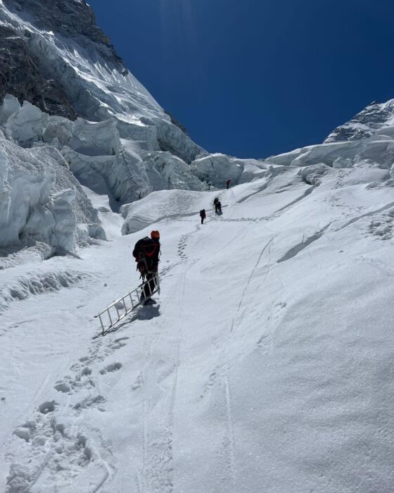 Climbers on the steep snow section at the Khumbu Icefall of Everest with seracs on both sides