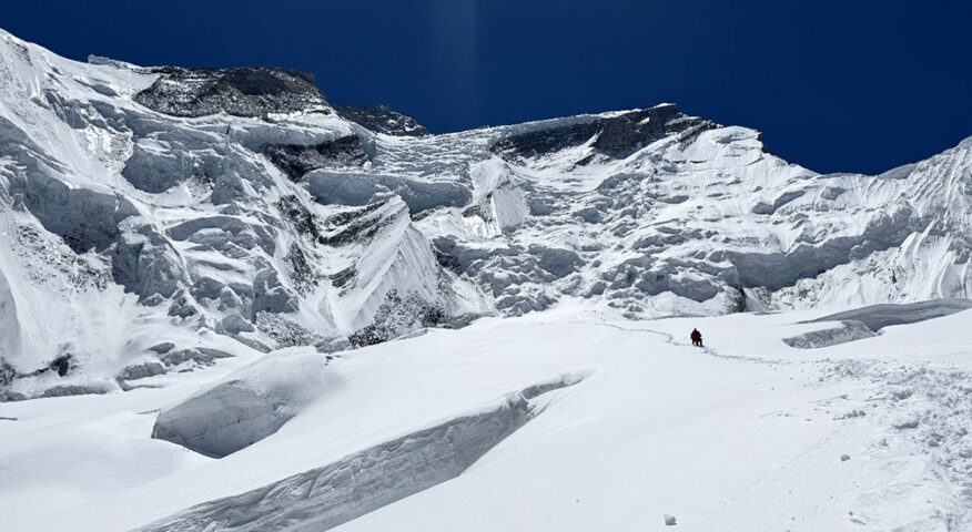 climbers on ascent on Annapurna, walk on a snow field approaching a maze or seracs and crevasses.