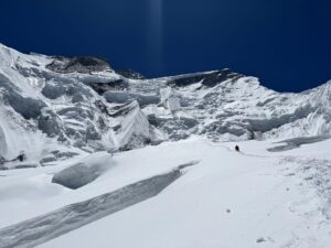 climbers on ascent on Annapurna, walk on a snow field approaching a maze or seracs and crevasses.