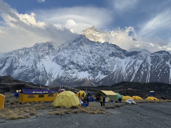 tents on a flat surface of morraine terrain, Annapurna behind.