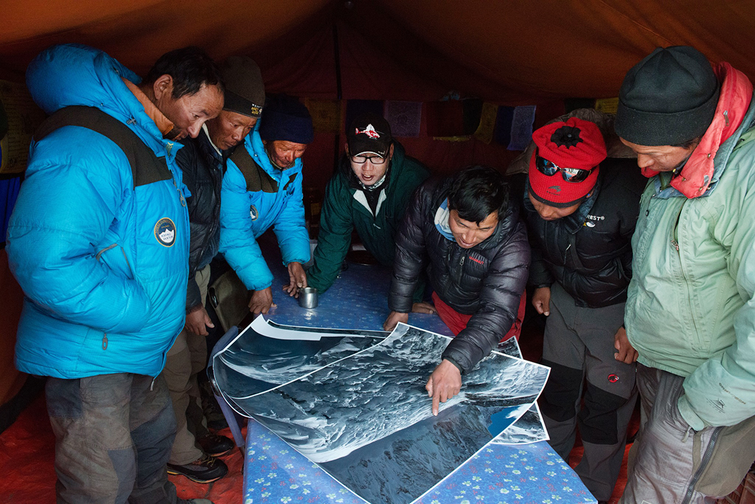 Sherpas check maps on a table.