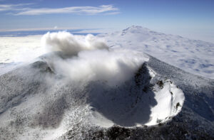 smoking crater on snowy volcano