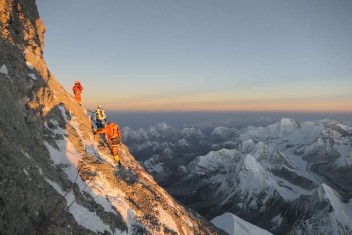 Climbers on the upper sections of Everest, north side, at sunrising. 