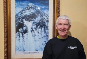 Valeri Babanov poses beside a photo of Everest.