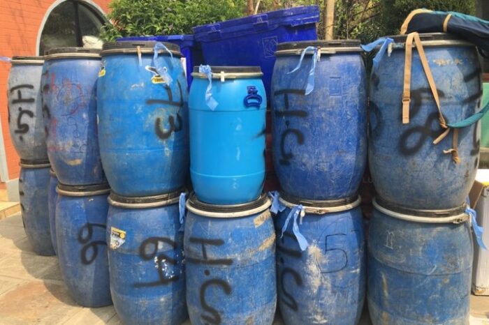 Blue plastic barrels piled up. 
