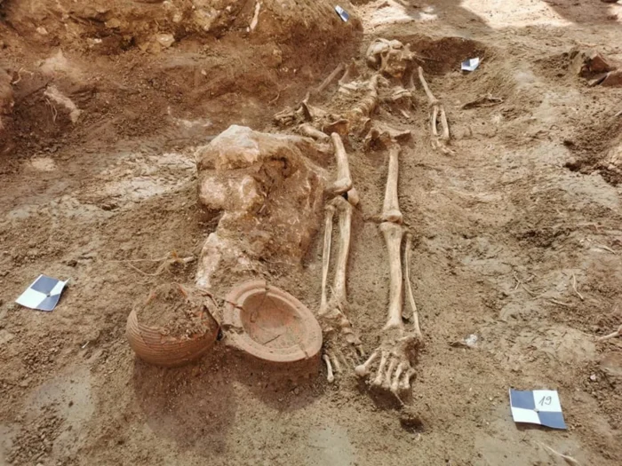unburied skeleton and jars