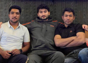 The three pakistani climbers sitting in an indoor place.