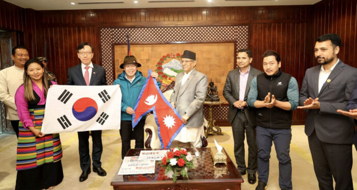 the climbers and poititians pose with South Korean and Nepalese flags.