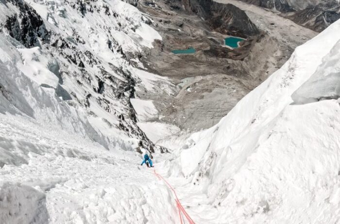 A climber on a vertical ice gully, Lakes in background