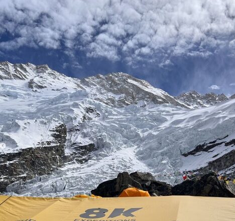 Kangchenjunga under some clouds with a tent in front