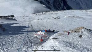 A dead body on the snow on Everest and ropes going down the slope