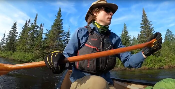 a man paddles a canoe
