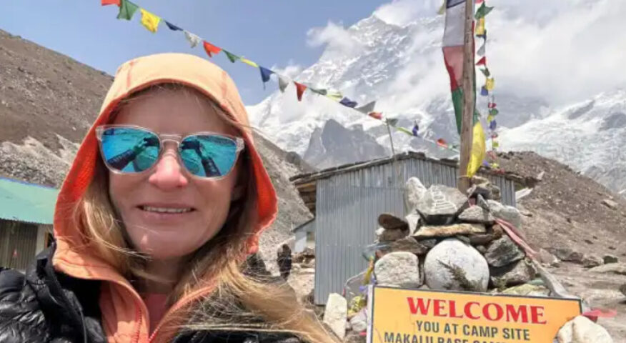 Allie Pepper poses in front of the board at Makalu Base Camp