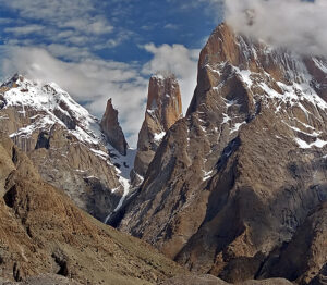 The Trango Towers partially capped by clouds