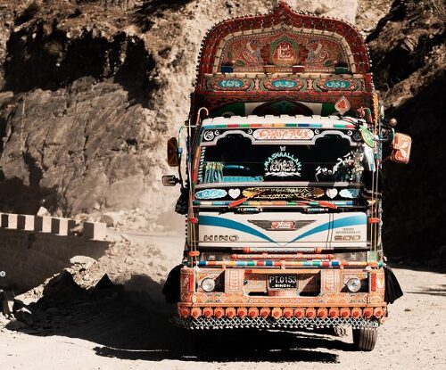 A truck on a dirt road in a mountain area.