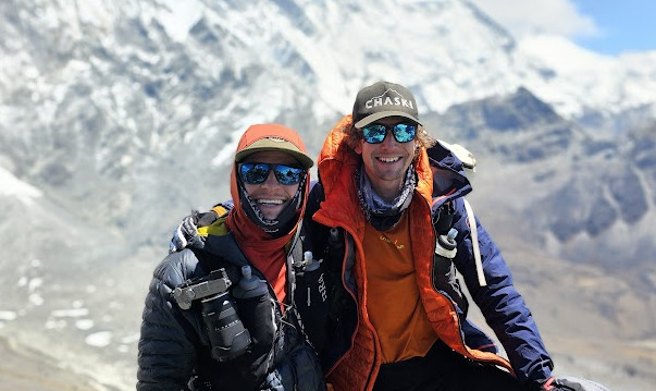 the climbers smile on the summit of Chhukkung Ri, with sunglasses, mountain clothes and caps. 