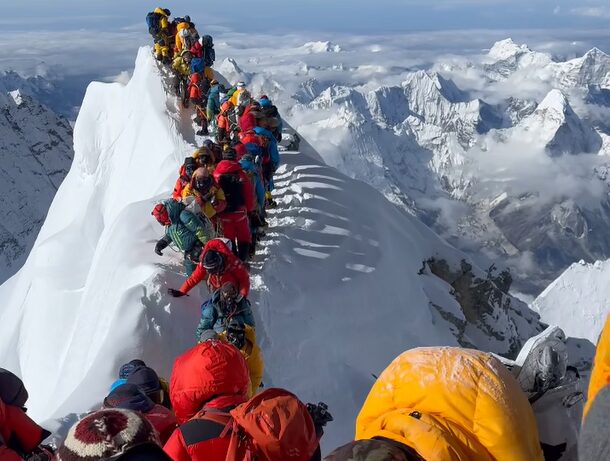 Climbers jam the narrow snow ridge to step on the summit of Everest