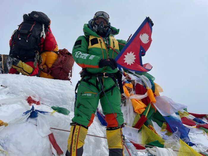 Kami Rita with green dawn suit and O2 mask on the summit of Everest.