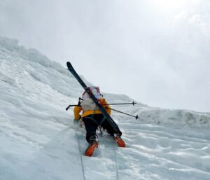 Ziemski climbing on vertical ice with fixed ropes on Makalu, skis on his back