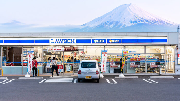a view of a convenience store with Mount Fuji rising in the background