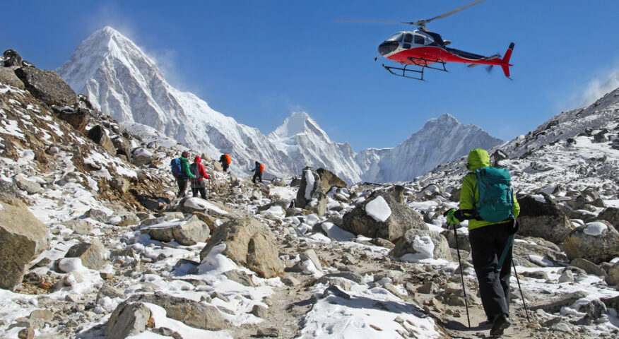 A trekker looks up to a helicopter flying low in the vicinity of Everest Base Camp