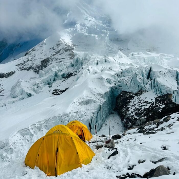 a tent by a serac in a rough section of Cho Oyu