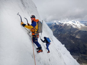 Climbers on a steep snow/ice face, leaning on crampon points and ice-axes