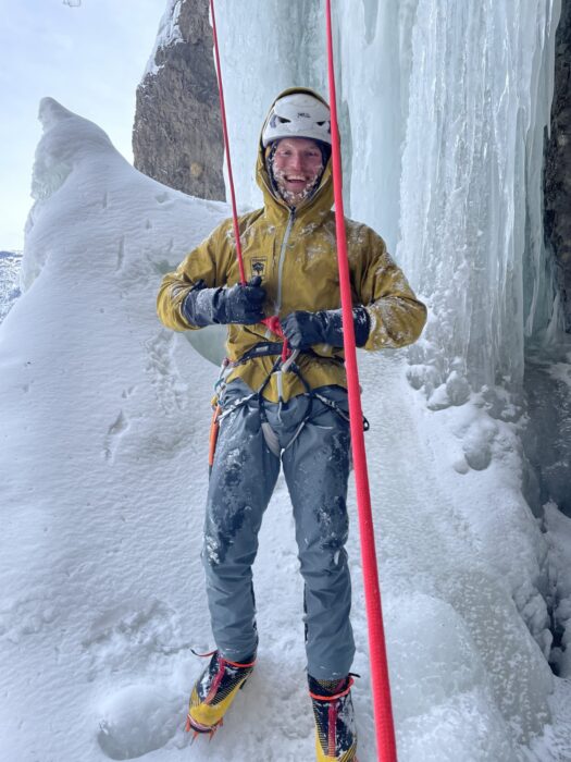 Steadman covered in frost and still tied up to a rope after climbing an ice route. 