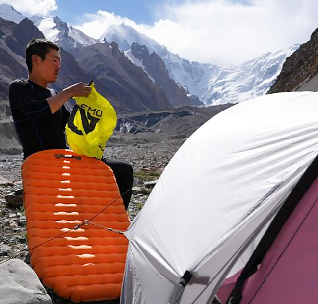 Nakajima by a tent with an inflatable pad.