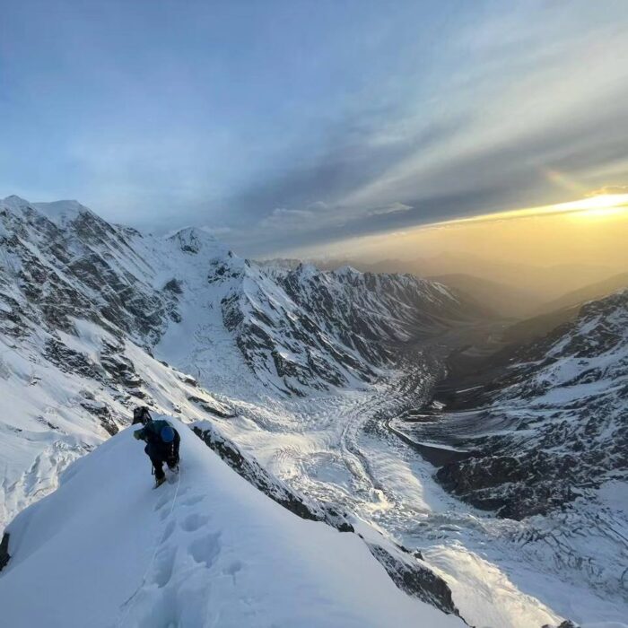 Pakistani climber on a snow ridge in dim light. 