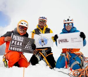 The climbers on the summit holding banners of sponsors.