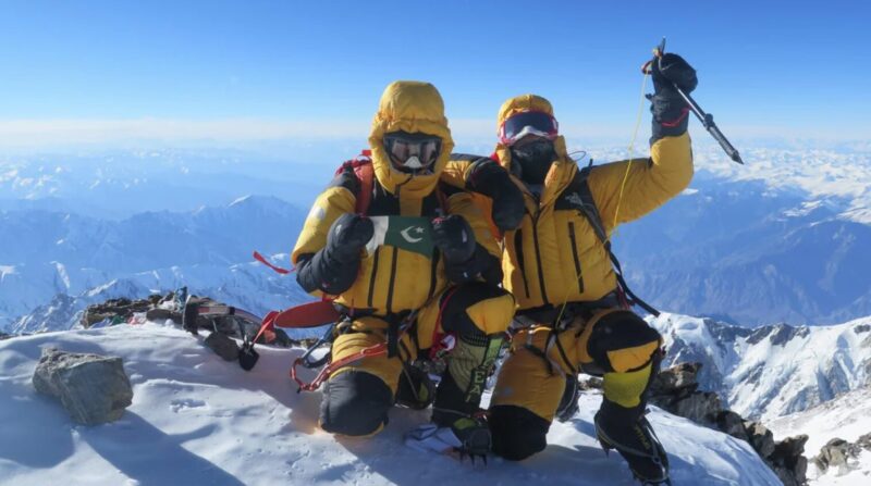 two mountaineers in yellow on the summit of Nanga Parbat